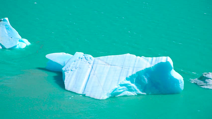 Perito Moreno Glacier in Argentina showcases icebergs floating in turquoise water, reflecting sunlight and creating a serene landscape.