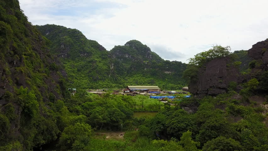 Discover the unique aerial perspective of an agricultural area nestled near the impressive rock formations of Ninh Binh, Vietnam. This view highlights the interplay between human activity.