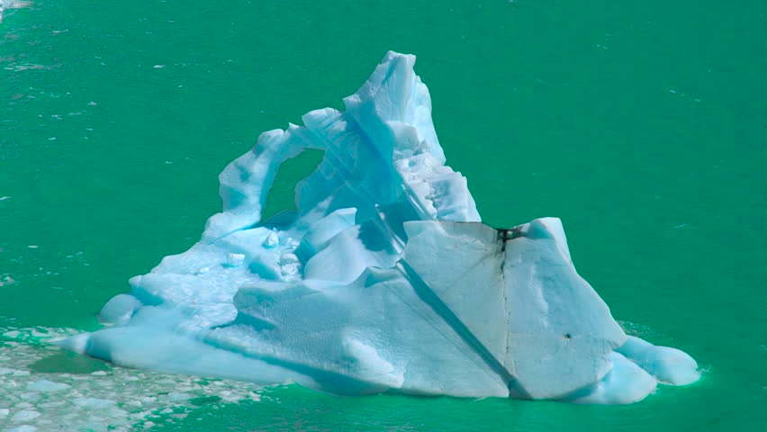 Perito Moreno Glacier in Argentina displays massive ice formations and turquoise waters, prominently showcasing calved icebergs near the glacier's edge.