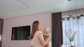 A young woman happily tosses a baby above her in a bright room. - Powered by Shutterstock - Get 15% off with code: PIKWIZARD15