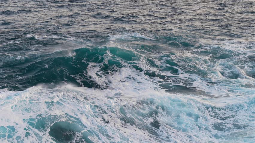 Epic ocean wave with turquoise water. Big power wave splash with white foam, slow motion shot. Sunrise reflecting in ocean water surf. Aerial shot
