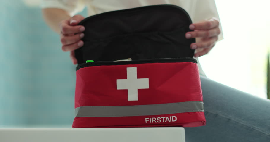 Woman open the first aid kit at home. First aid kit.