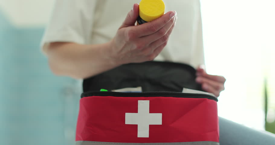 Woman takes out pills from first aid kit at home.
