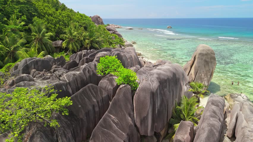 Aerial shot of famous beach with crystal clear water and rocks - Anse Source d