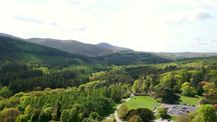 Wide advancing aerial video of the Mourne Mountains and Slieve Donard in Newcastle, County Down in Northern Ireland, UK on a bright and sunny day. Filmed in 4K, 60fps and with Rec709 Color.