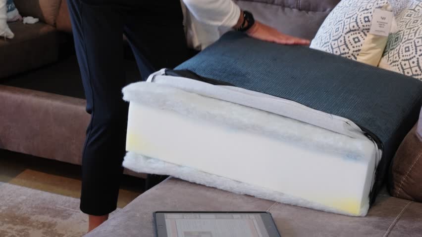 Hands reveal dacron wrap and memory foam core in blue cushion build