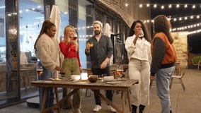 Diverse group of young friends sharing drinks, laughter, and animated conversation during rooftop nightlife gathering, celebrating friendship and connection - Powered by Shutterstock - Get 15% off with code: PIKWIZARD15