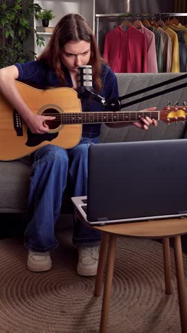 Young Woman Playing Acoustic Guitar During Online Recording