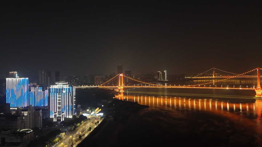 aerial panning of Wuhan Yingwuzhou Yangtze River Bridge and city at night