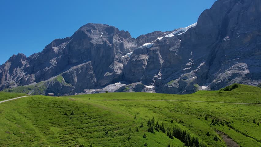 Cinematic drone shot flying over mountain of Grindelwald valley in Switzerland Bernese Alps