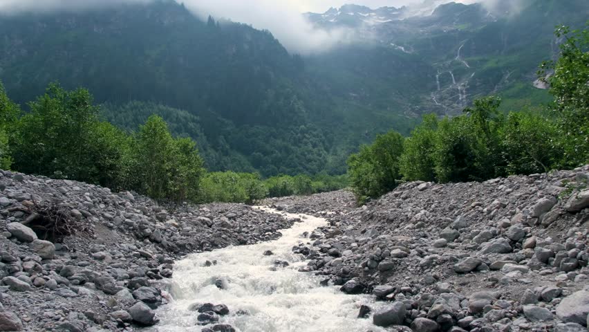 Steady shot of flowing mountain river of Grindelwald valley in Switzerland Bernese Alps