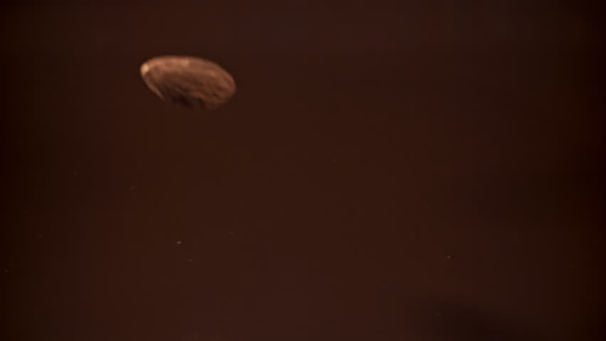 The almonds fall into the melted chocolate. Filmed on a high-speed camera at 1000 fps. High quality FullHD footage