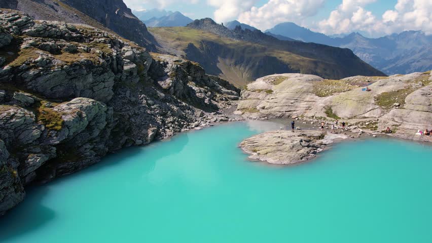 Aerial sunny day on turquoise Schottensee lake on Five Lake hiking path in Pizol Switzerland. Travel destination and popular trail.