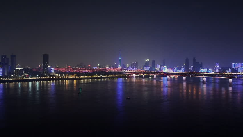 aerial Wuhan city landscape and Wuhan Yangtze River Bridge at night, drone ascend view
