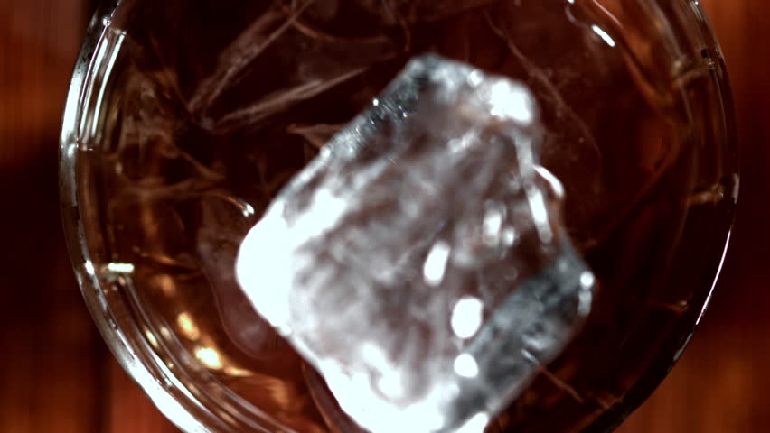 Ice falls into a glass of whiskey. Filmed on a high-speed camera at 1000 fps. High quality FullHD footage
