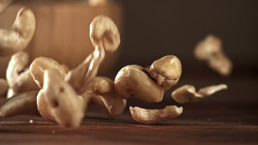 Cashews fall on a wooden table. Filmed on a high-speed camera at 1000 fps. High quality FullHD footage