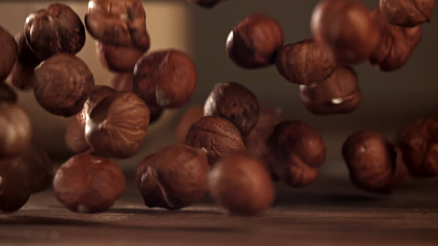 Hazelnuts fall on a wooden table. Filmed on a high-speed camera at 1000 fps. High quality FullHD footage