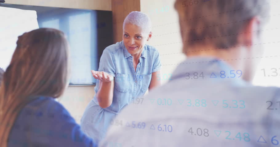 Instructor facilitating business training in conference room displaying flip chart and data graphs. Professional, training, education, seminar, presentation, workshop, corporate