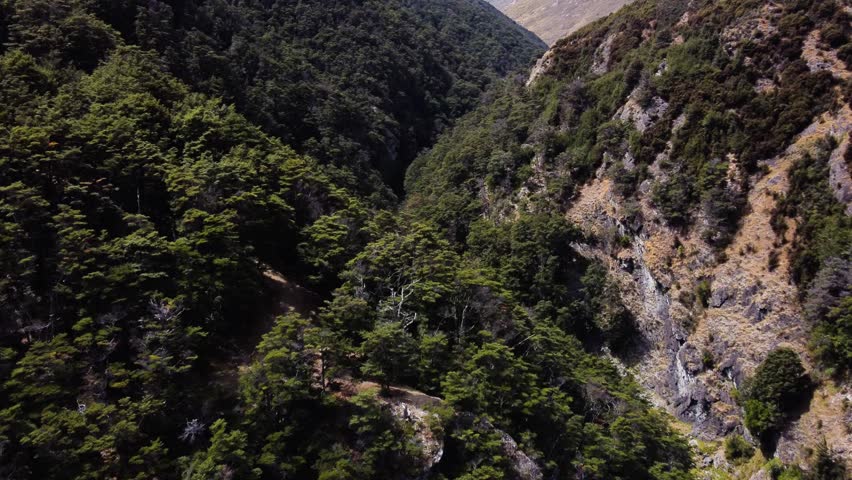 AERIAL Fly-by over a Stunning Mountain Valley deep in the Mountains of South Island, New Zealand
