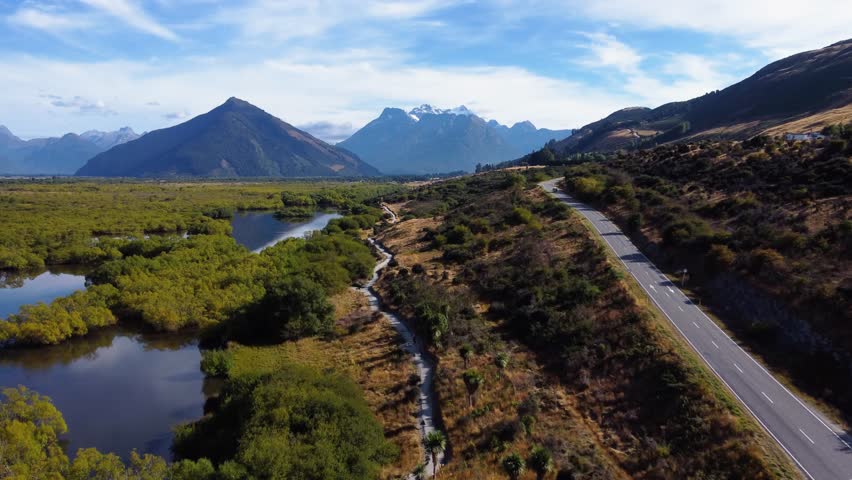 AERIAL Fly-by over a Gorgeous Mountain Landscape with a Road cutting through it in Glenorchy, New Zealand