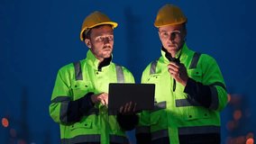 Industrial engineers consulting on petrochemical pipeline construction at an illuminated night factory. Professional teamwork shown in safety gear. - Powered by Shutterstock - Get 15% off with code: PIKWIZARD15