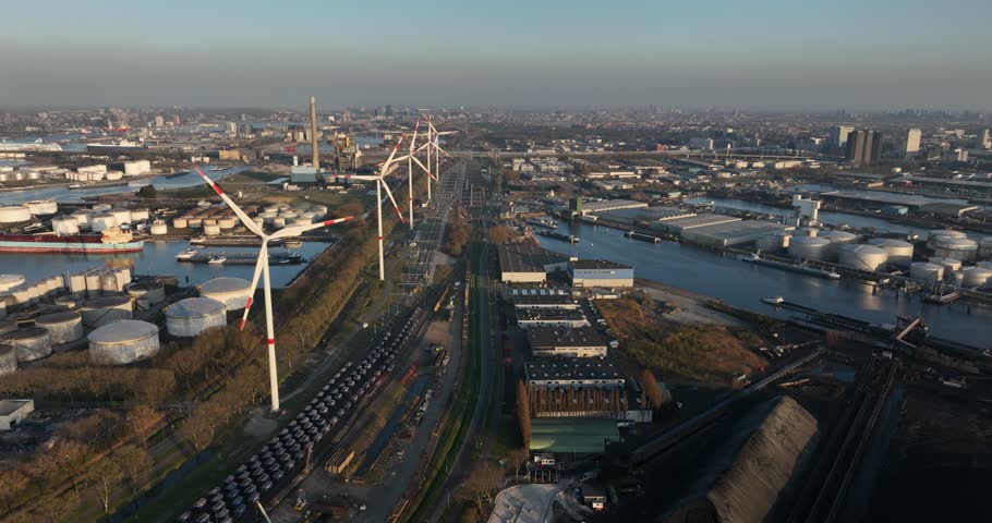 wind turbines in the port of Amsterdam, The Netherlands, renewable energy, heavy industrial zone, transport over water, petroleum sotrage silos, waterway, ships, commercial and industrial activities.