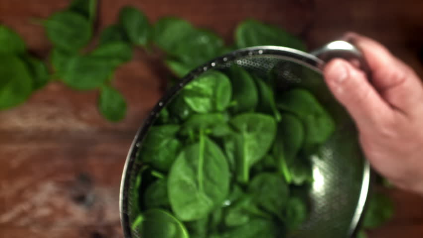 The chef tosses spinach in a saucepan. Filmed on a high-speed camera at 1000 fps. High quality FullHD footage