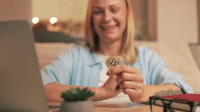 Confident businesswoman navigating bitcoin cryptocurrency on laptop while sit at wooden table in home office, wearing blue shirt and working remotely with enthusiasm.Cryptocurrency investment concept. - Powered by Shutterstock - Get 15% off with code: PIKWIZARD15
