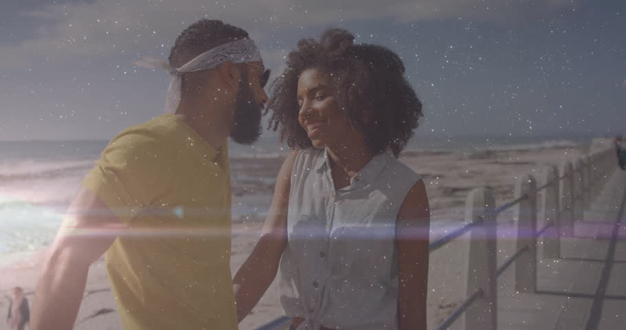 Man and woman walking beachfront promenade, displaying animated finance charts and money bag icons. Beach, sunset, leisure, romance, fashion, outdoor, happiness