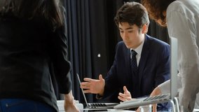 Business team collaborating around laptop, showing holographic cart and bar chart overlays. Technology, innovation, teamwork, digital, data, analytics, corporate - Powered by Shutterstock - Get 15% off with code: PIKWIZARD15