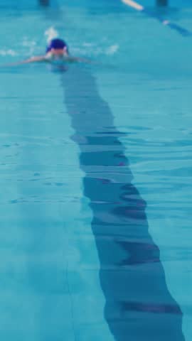 Young female swimmer performs swimming the butterfly technique. Theme of sport and endurance. A woman swimmer swims in the pool.