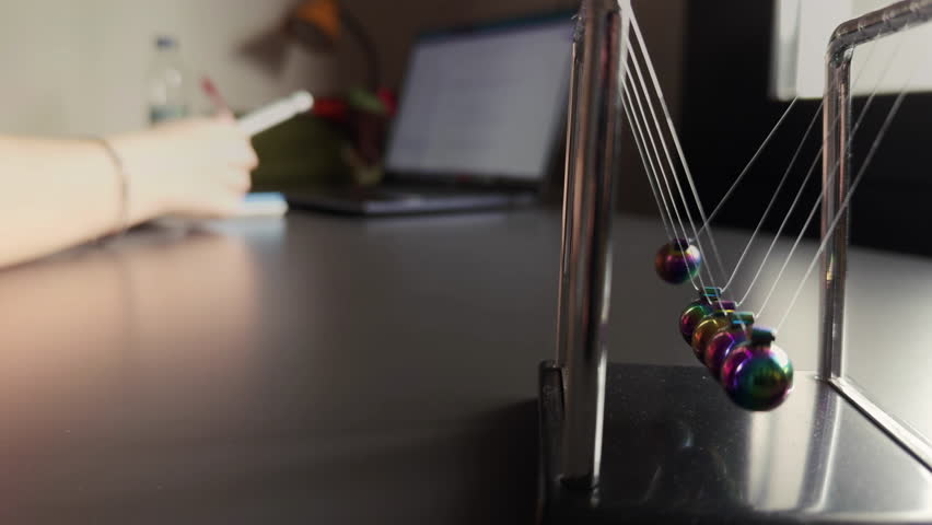 The Newtons Cradle and Studying on Laptop Educational Concept