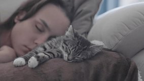 A serene and heartwarming image of a girl and her beloved cat peacefully sleeping together on a cozy couch - Powered by Shutterstock - Get 15% off with code: PIKWIZARD15