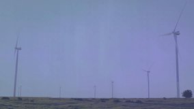 Translucent data overlay being animated over wind farm with bar charts and line graph traces. Analytics, renewable, technology, sustainability, visualization, eco, digital - Powered by Shutterstock - Get 15% off with code: PIKWIZARD15