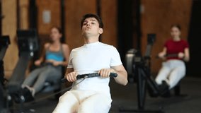 Guy exercises on a rowing machine in the gym. European man is preparing for the rowing competition. Fitness club client at a group cardio workout. High quality 4k footage - Powered by Shutterstock - Get 15% off with code: PIKWIZARD15