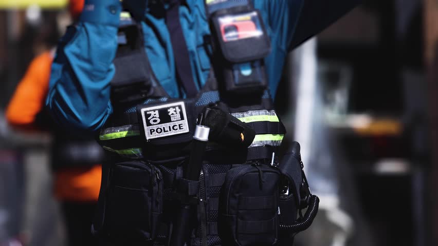 Korean police squad formation in uniform with "Police" logo, policemen maintain order and regulate traffic on incident and fire blaze site, crime scene, rescue operation in Busan city, South Korea 