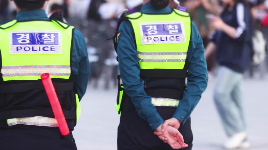 Korean police squad formation in uniform with "Police" logo, policemen officer patrol maintain public order during political demonstration protest rally in the streets of Busan center, South Korea 