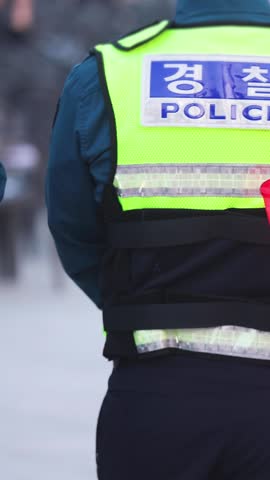 Korean police squad formation in uniform with "Police" logo, policemen officer patrol maintain public order during political demonstration protest rally in the streets of Busan center, South Korea 