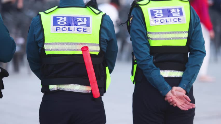 Korean police squad formation in uniform with "Police" logo, policemen officer patrol maintain public order during political demonstration protest rally in the streets of Busan center, South Korea 