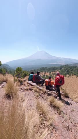 Hikers taking a break during their ascent, enjoying the view of the majestic iztaccíhuatl volcano in mexico