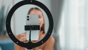 Young woman making beauty and cosmetic tutorial video content for social media. Beauty blogger smiles to camera while showing how to beauty care to audience or followers. Adit - Powered by Shutterstock - Get 15% off with code: PIKWIZARD15