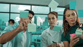 Professional business team brainstorm, sharing, thinking idea while skilled male leader write on sticky notes at glass wall. Skilled manager placed business plan on glass wall at office. Tracery - Powered by Shutterstock - Get 15% off with code: PIKWIZARD15