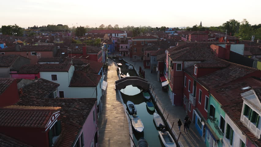 Mooring Boats Over Canals In The Fishing Village At Sunset On Burano Island Near Venice, Italy. Aerial Drone Shot