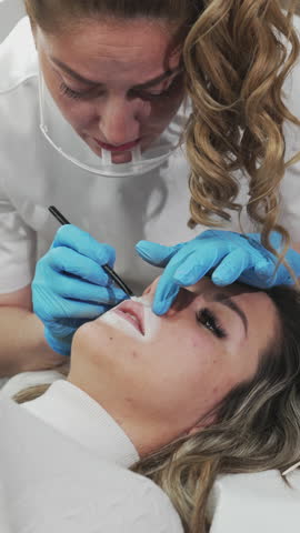 Professional permanent make-up procedure. Tattoo lips makeup treatment in modern beauty salon.