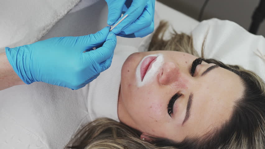 Professional permanent make-up procedure. Tattoo lips makeup treatment in modern beauty salon.