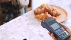 Senior entrepreneur cafe owner barista holds POS terminal while customer swipes creditcard, Asian retired female in apron smiling at counter, demonstrating cashless payment inside modern coffee shop - Powered by Shutterstock - Get 15% off with code: PIKWIZARD15