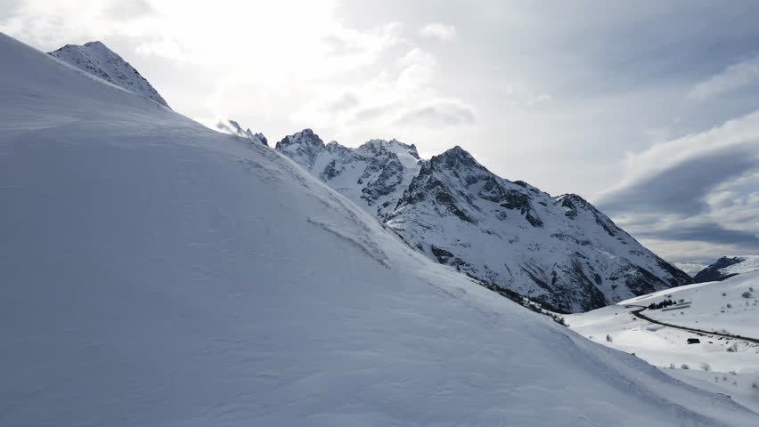 A breathtaking aerial view of snow-covered mountain peaks, showcasing serene alpine landscapes and crisp natural beauty during winter