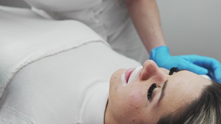 Professional permanent make-up procedure. Tattoo lips makeup treatment in modern beauty salon.