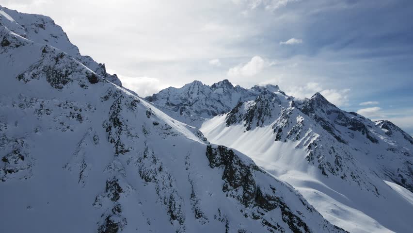 A breathtaking aerial view of snow-covered mountain peaks, showcasing serene alpine landscapes and crisp natural beauty during winter