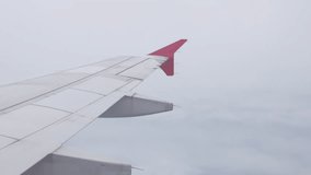 view through plane window from inside airplane cabin while climbing flying over the sky with airplane wing winglet and fluffy cloud outside in summer daytime - Powered by Shutterstock - Get 15% off with code: PIKWIZARD15